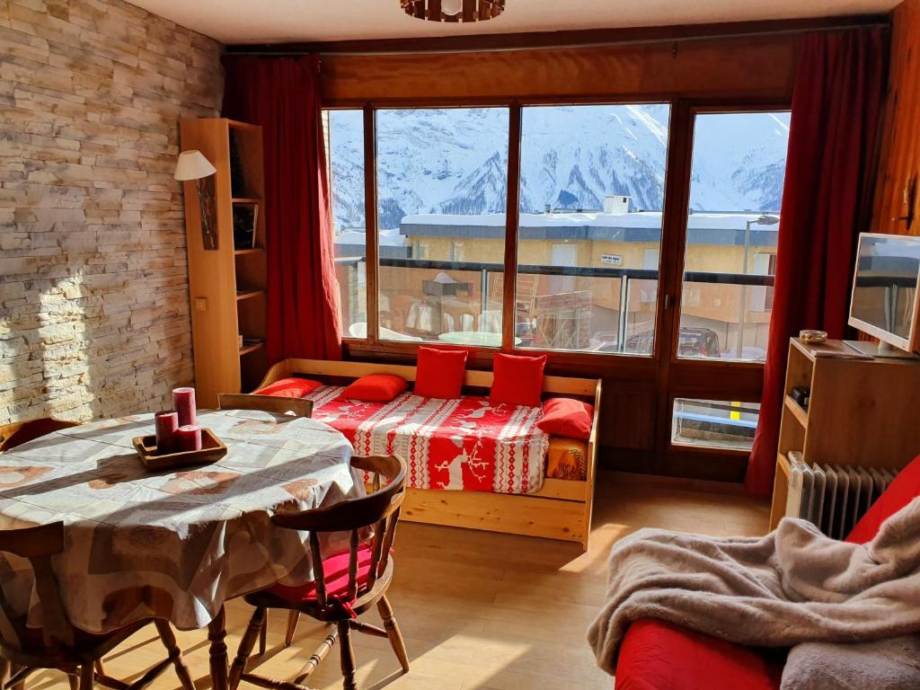 Cette chambre comprend une table, un lit et une fenêtre. dans l'établissement Studio Queyrelet 1 pied des pistes avec balcon & vue 2-4 personnes, à Orcières 16 autres photos