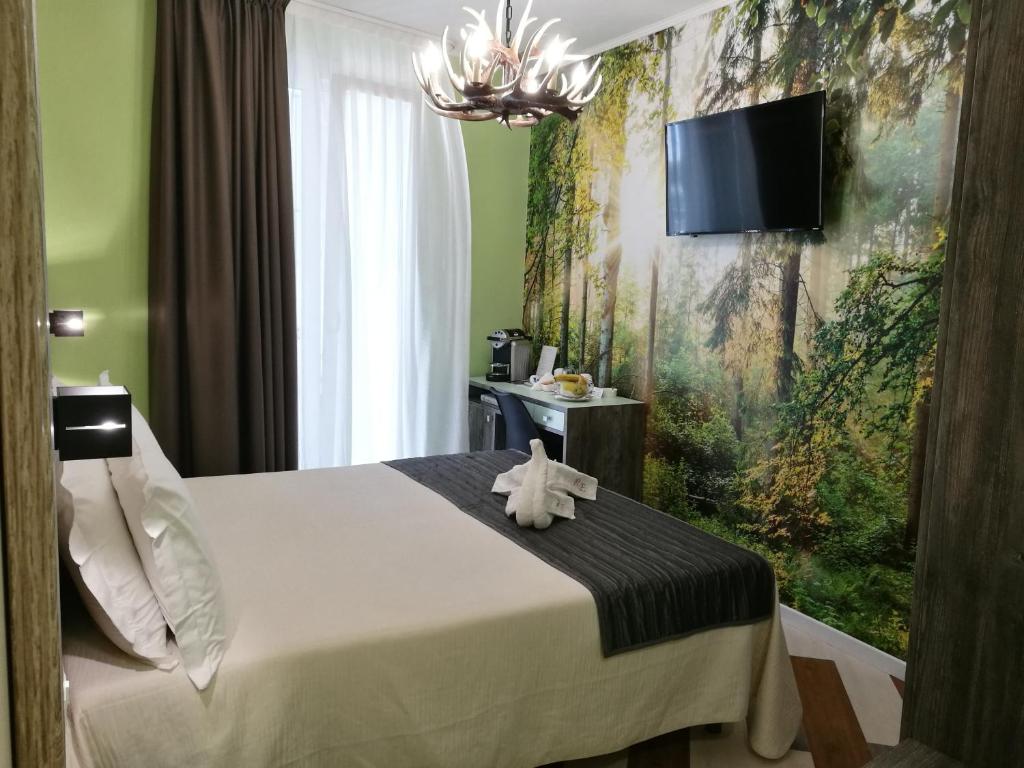 une chambre avec un lit et une télévision sur un mur dans l'établissement Residence Eleonora, à Sottomarina