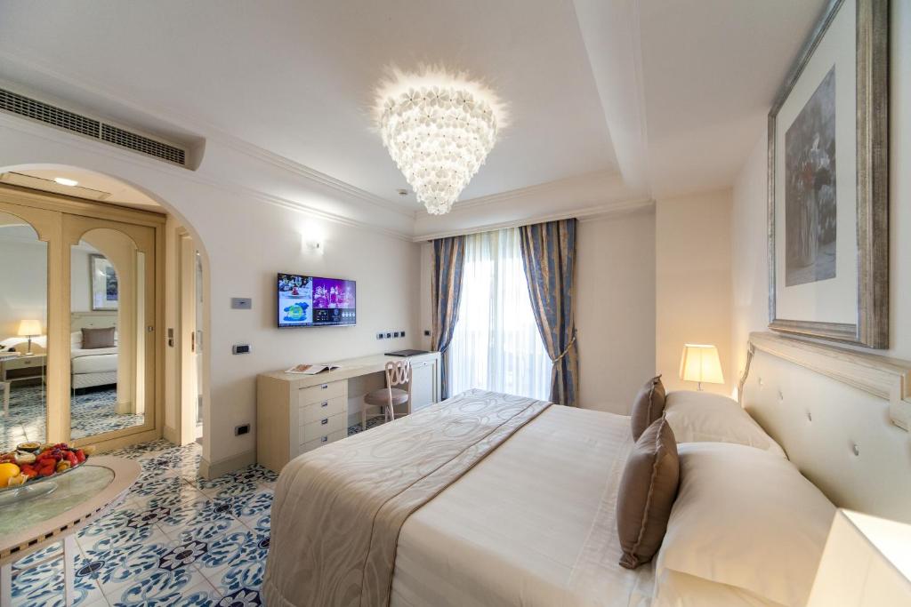 une chambre avec un grand lit et un lustre dans l'établissement Palace Hotel, à Milano Marittima