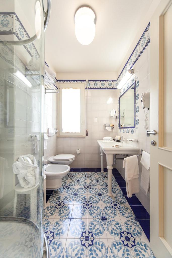 une salle de bain avec toilettes, lavabo et douche dans l'établissement Palace Hotel, à Milano Marittima