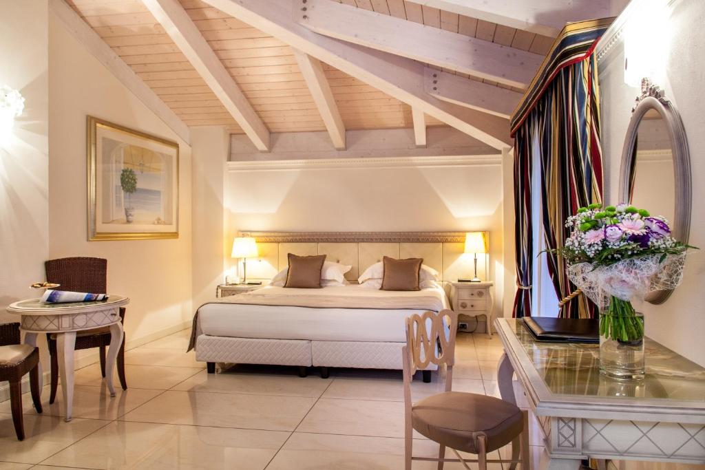 une chambre d'hôtel avec un lit et un bureau et une chambre dans l'établissement Palace Hotel, à Milano Marittima