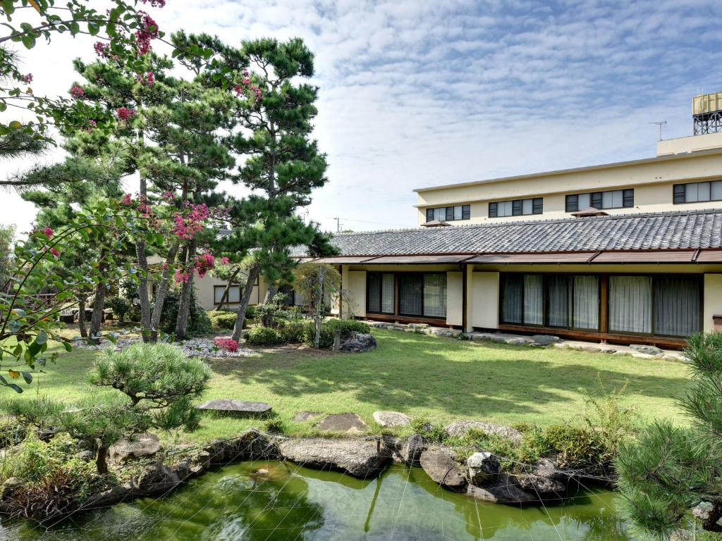 une maison avec un jardin et un étang dans l'établissement Hotel Hagoromo, à Shizuoka
