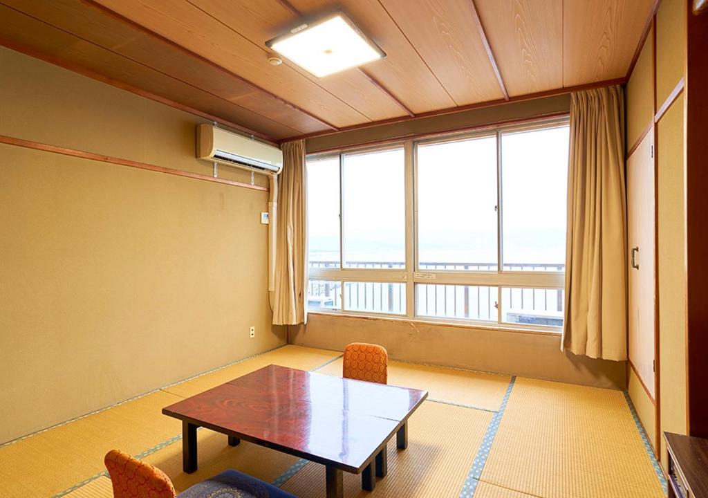 une pièce avec une table et des chaises et une grande fenêtre dans l'établissement Shinwaka Lodge, à Wakayama
