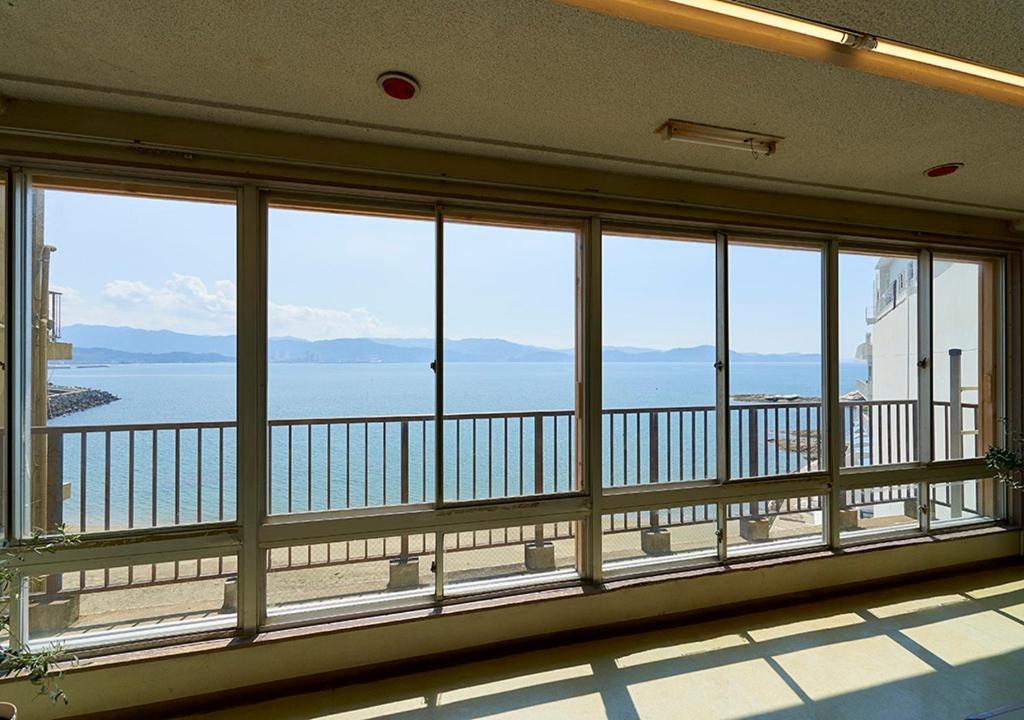 Cette grande chambre dispose d'un balcon avec vue sur l'eau. dans l'établissement Shinwaka Lodge, à Wakayama