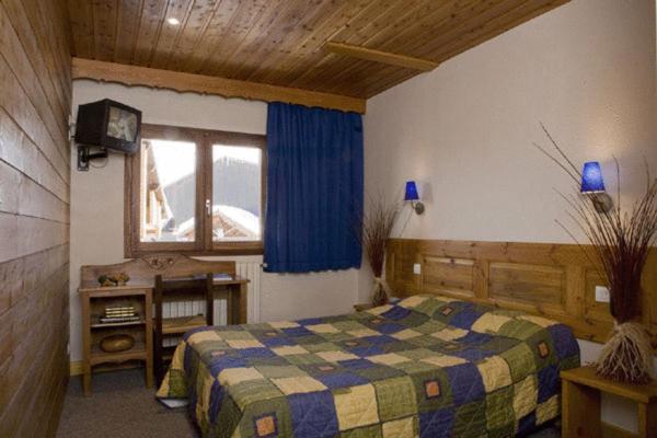 une chambre avec un lit et une fenêtre dans l'établissement Chalet-Hôtel Alpage & SPA, à Vars