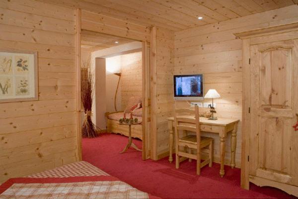 Cette chambre en bois comprend un bureau et une chambre. dans l'établissement Chalet-Hôtel Alpage & SPA, à Vars