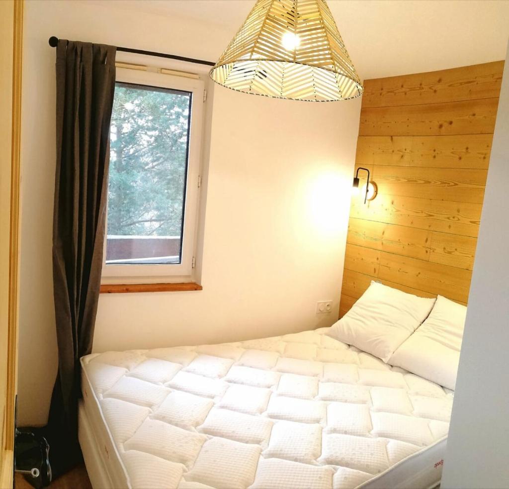 une chambre avec un lit et une fenêtre dans l'établissement Appartement 3 pièces, 2 chambres au cœur de la station, à Val Louron