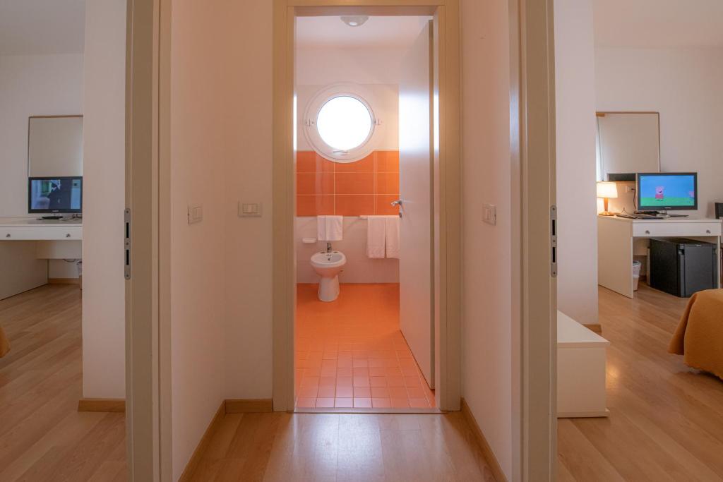 une salle de bain avec toilettes dans une pièce avec fenêtre dans l'établissement Hotel Parigi, à Caorle 110 autres photos