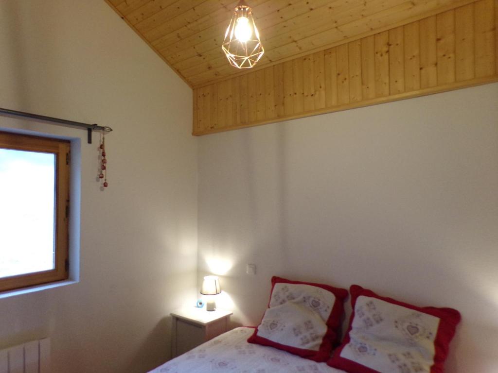 - une chambre avec un lit, une fenêtre et une lampe dans l'établissement Chalet Le Telemark wifi fibre et garage, à Thollon-les-Mémises