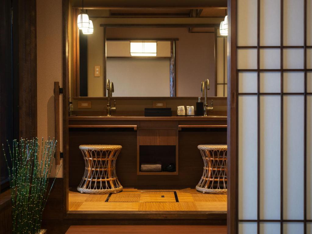 une salle de bain avec un lavabo et un miroir dans l'établissement Koran no Yu Kinkouro, à Ibusuki