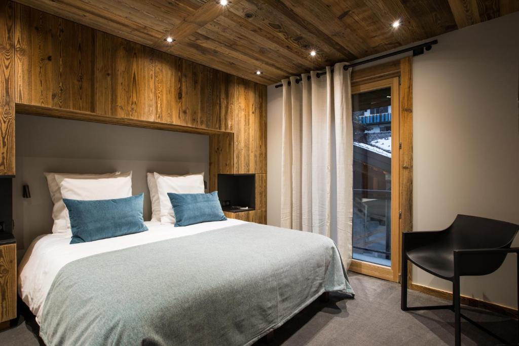une chambre avec un grand lit et une fenêtre dans l'établissement Le Chalet Nativ, à Morzine