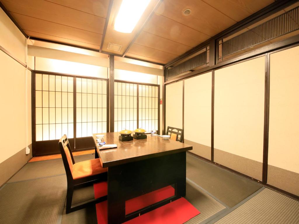 une salle de conférence avec une table, des chaises et des fenêtres dans l'établissement Ginshotei Awashima, à Numata 37 autres photos