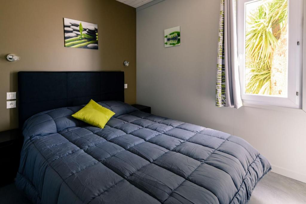 - une chambre avec un lit bleu et un oreiller jaune dans l'établissement VILLAGE CLUB LES SABLONS, à Portiragnes 37 autres photos