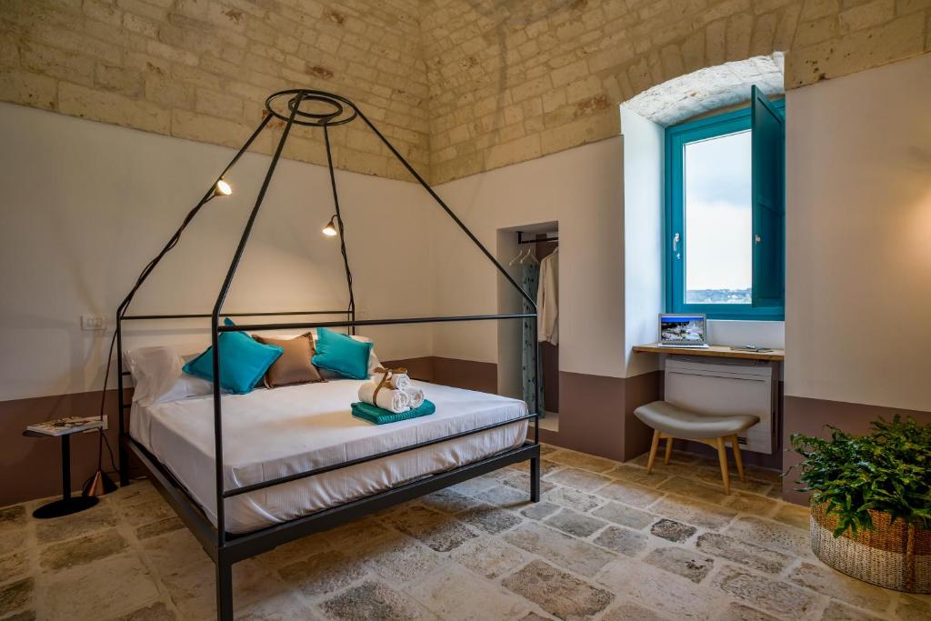 - une chambre avec un lit à baldaquin et une fenêtre dans l'établissement Borgo Aratico, à Monopoli 119 autres photos