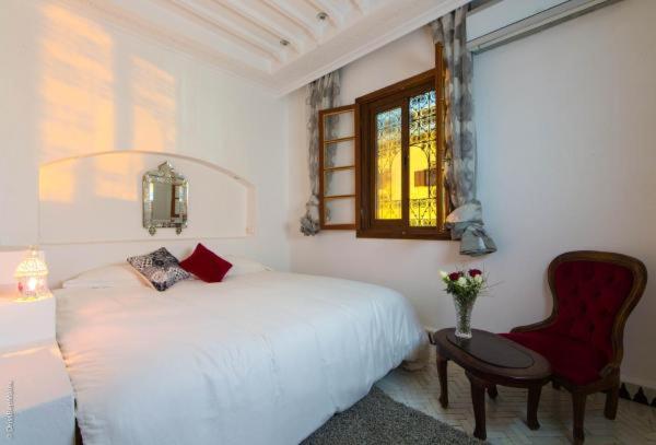 une chambre avec un lit, une chaise et une fenêtre dans l'établissement Riad Yacout, à Meknès