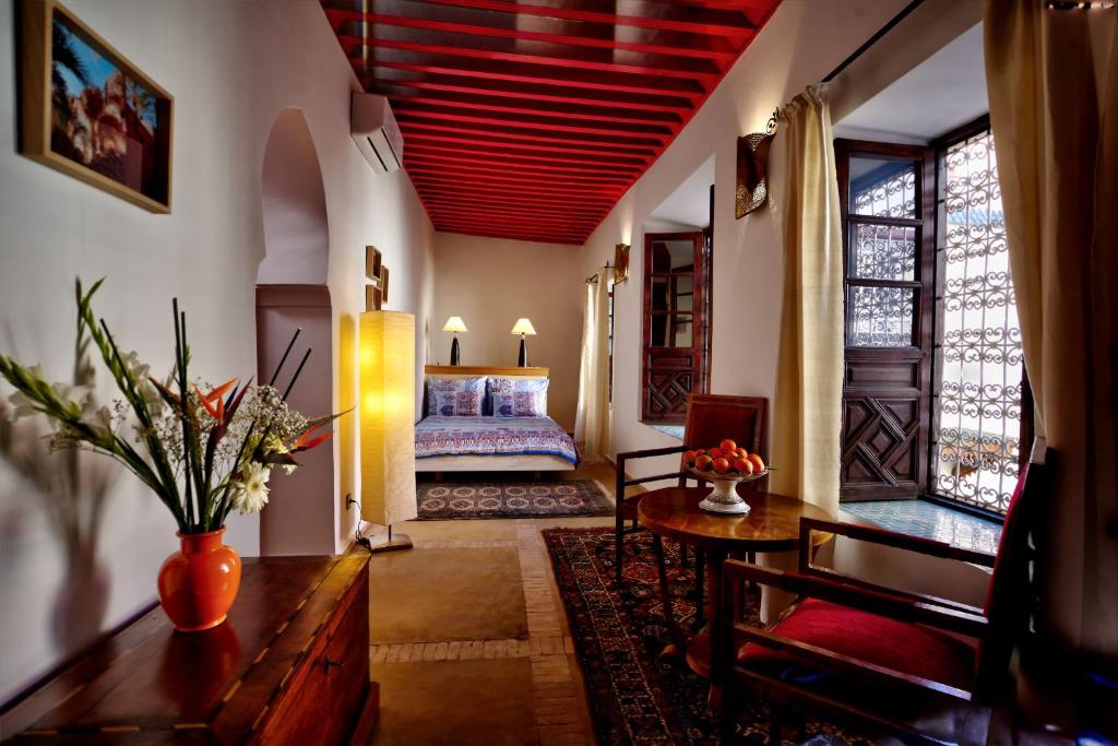 une chambre avec un lit, une table et un canapé dans l'établissement Riad Aventurine, à Marrakech