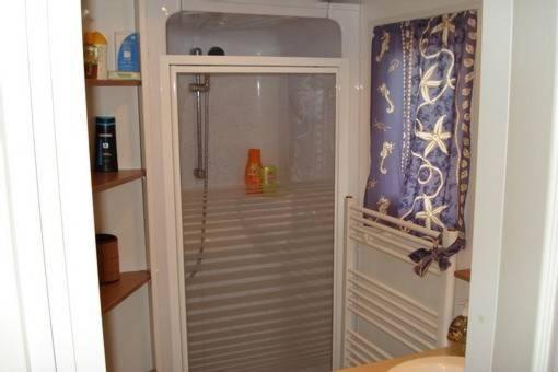 une salle de bain avec douche et porte vitrée dans l'établissement Mobilhome sur camping le kontiki **** ramatuelle, à Saint-Tropez