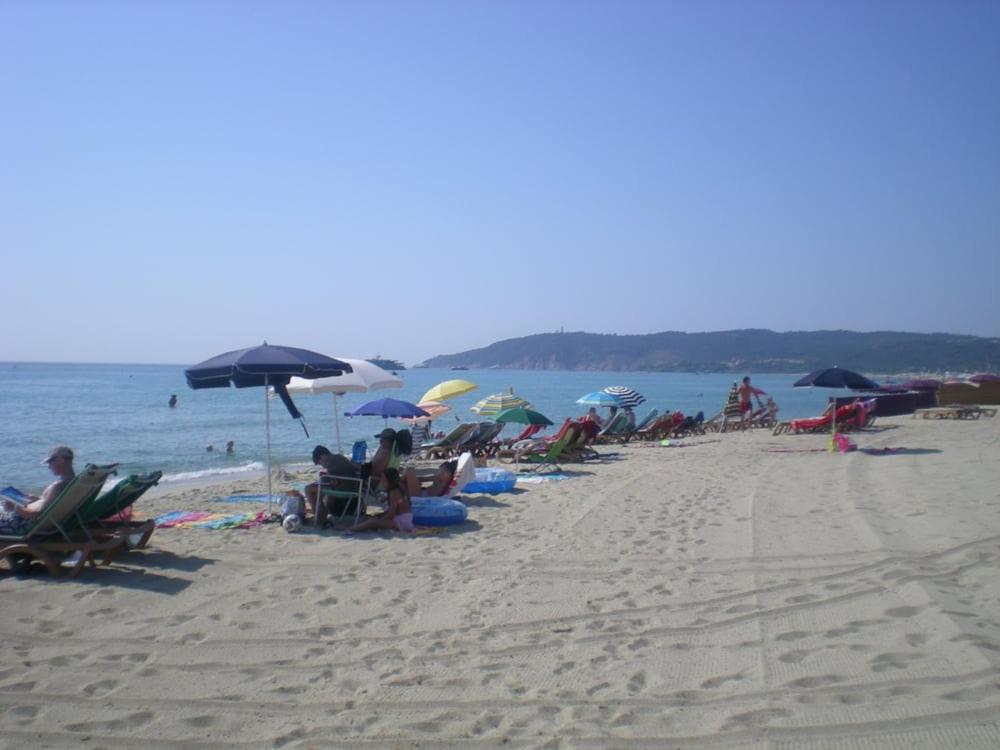 un groupe de personnes assises sur une plage avec des parasols dans l'établissement Mobilhome sur camping le kontiki **** ramatuelle, à Saint-Tropez