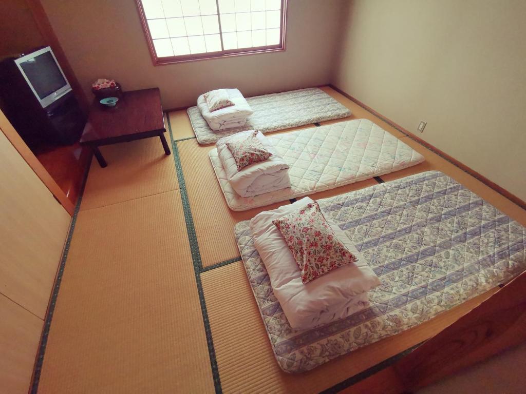 - une chambre avec 2 lits dans l'établissement たから温泉民宿 Gem Onsen Stay, à Sakaimura