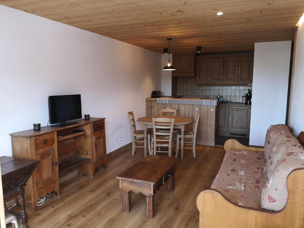 une cuisine et un salon avec une table et un canapé dans l'établissement Chalet Les Combes, à Notre-Dame-de-Bellecombe