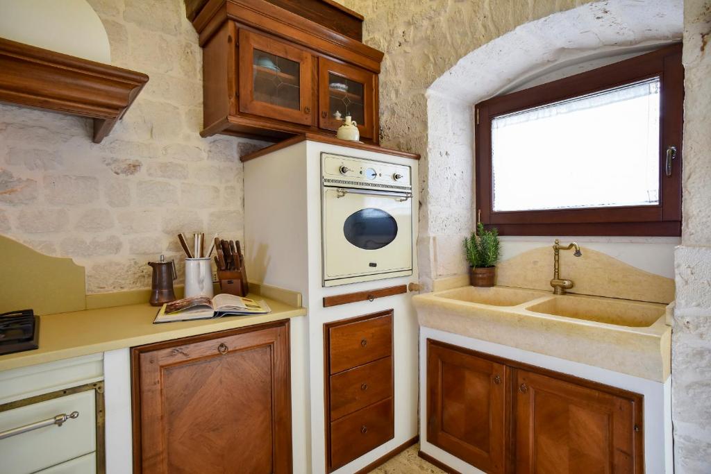 une cuisine avec un évier et un lave-vaisselle dans l'établissement Casale Lillina, à Castellana Grotte