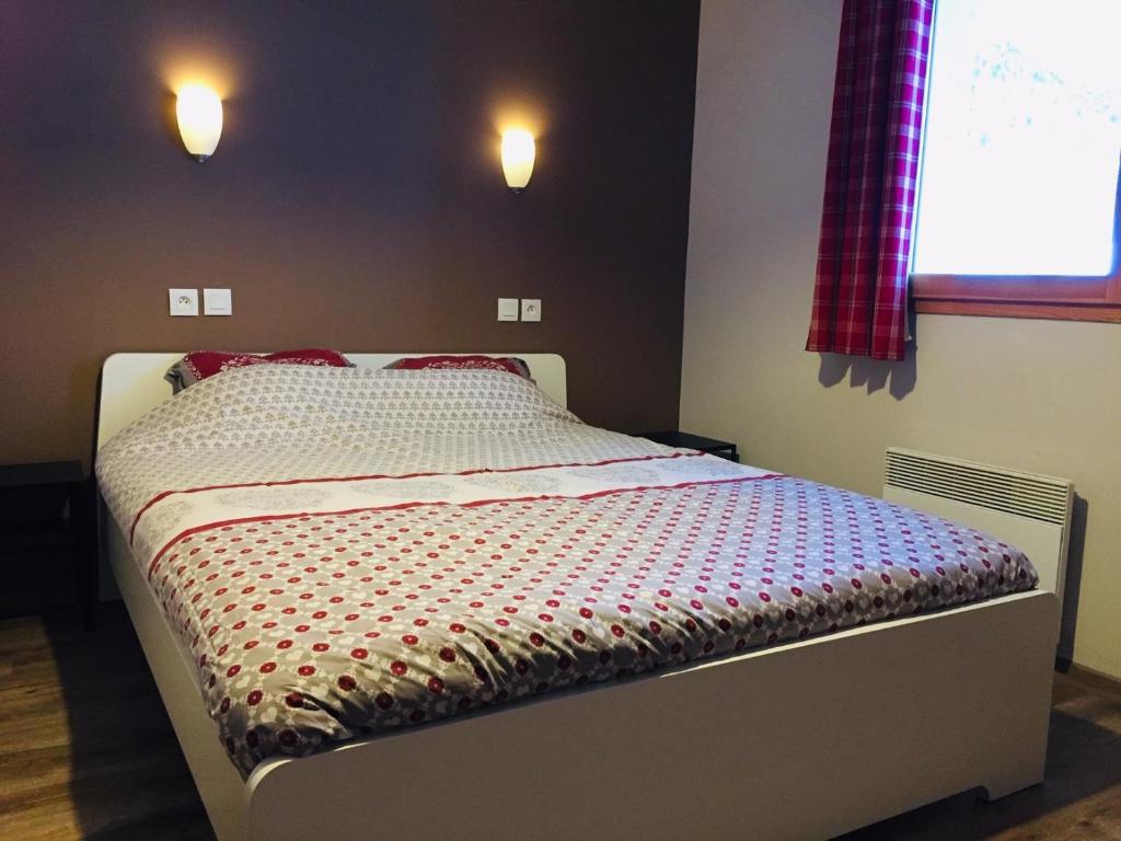 un petit lit dans une chambre avec une fenêtre dans l'établissement Duplex Familial à Vars, Chalets des Rennes, à Vars