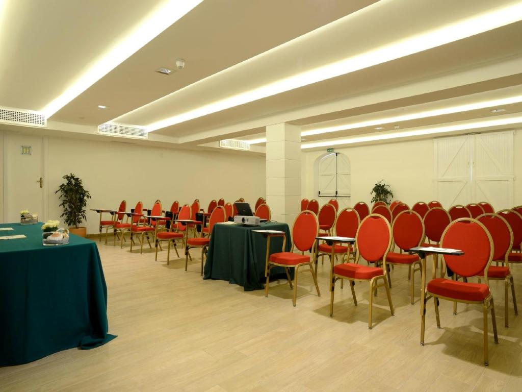 une salle de conférence avec tables et chaises et tablesearcher dans l'établissement Hotel Dei Pini, à Alghero 187 autres photos