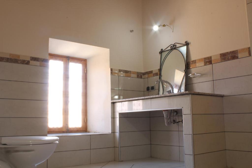 une salle de bain avec toilettes, lavabo et miroir dans l'établissement Riad Amodou, à Tinghir