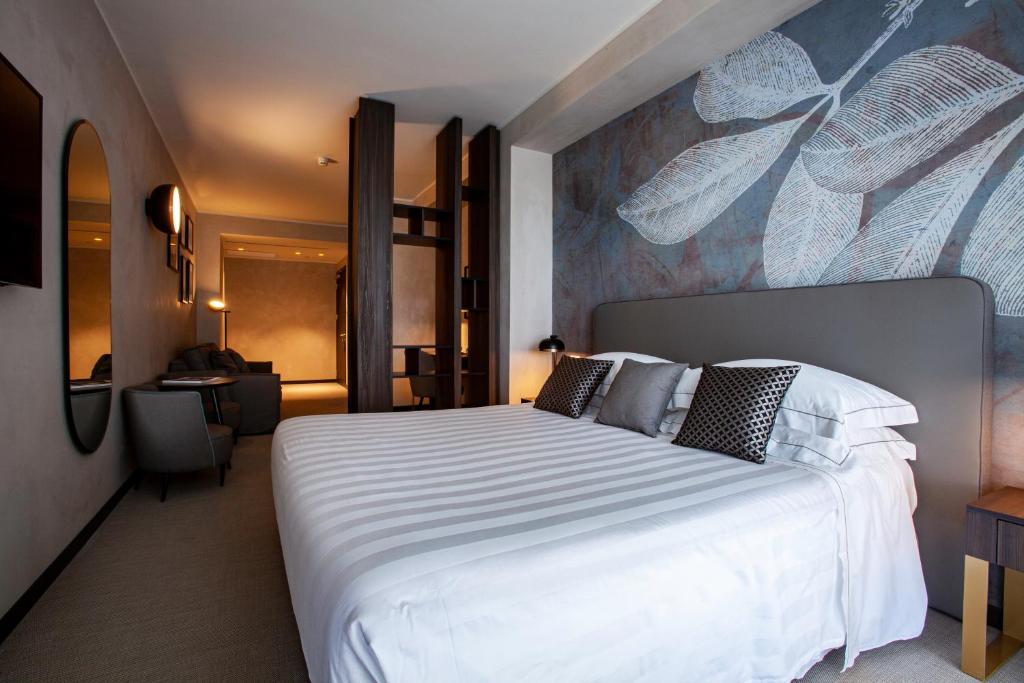 une chambre avec un grand lit blanc dans une pièce dans l'établissement Diana Grand Hotel, à Alassio