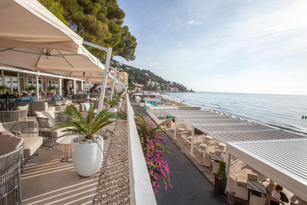 - une plage avec des tables, des chaises et l'eau dans l'établissement Diana Grand Hotel, à Alassio