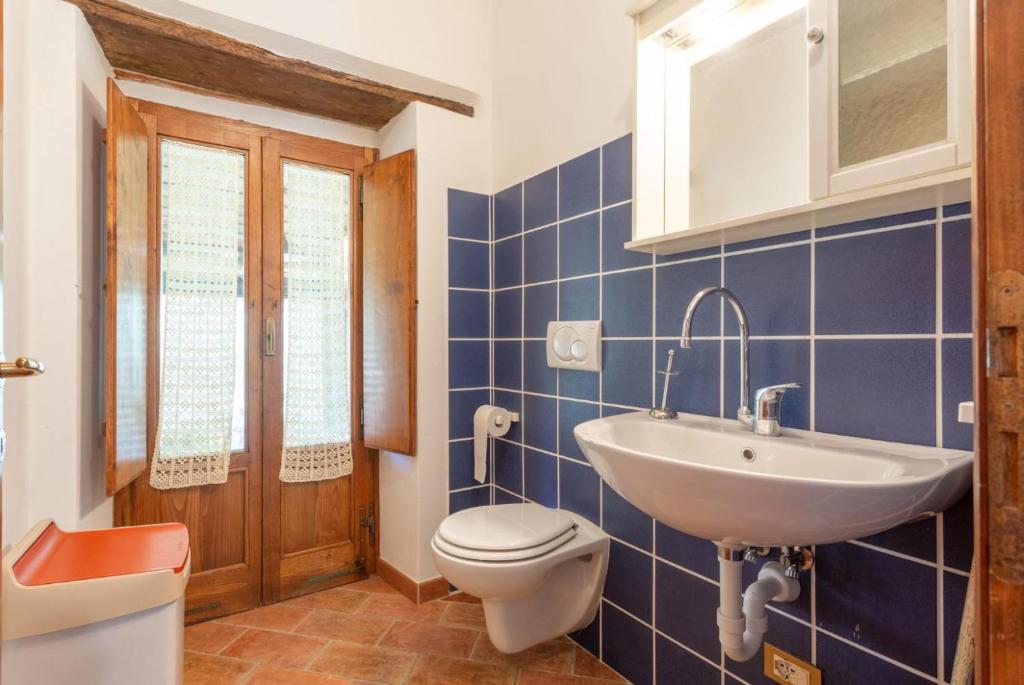 La salle de bains est pourvue de carrelage bleu, de toilettes et d'un lavabo. dans l'établissement Villa Bellavista, à Arezzo 43 autres photos