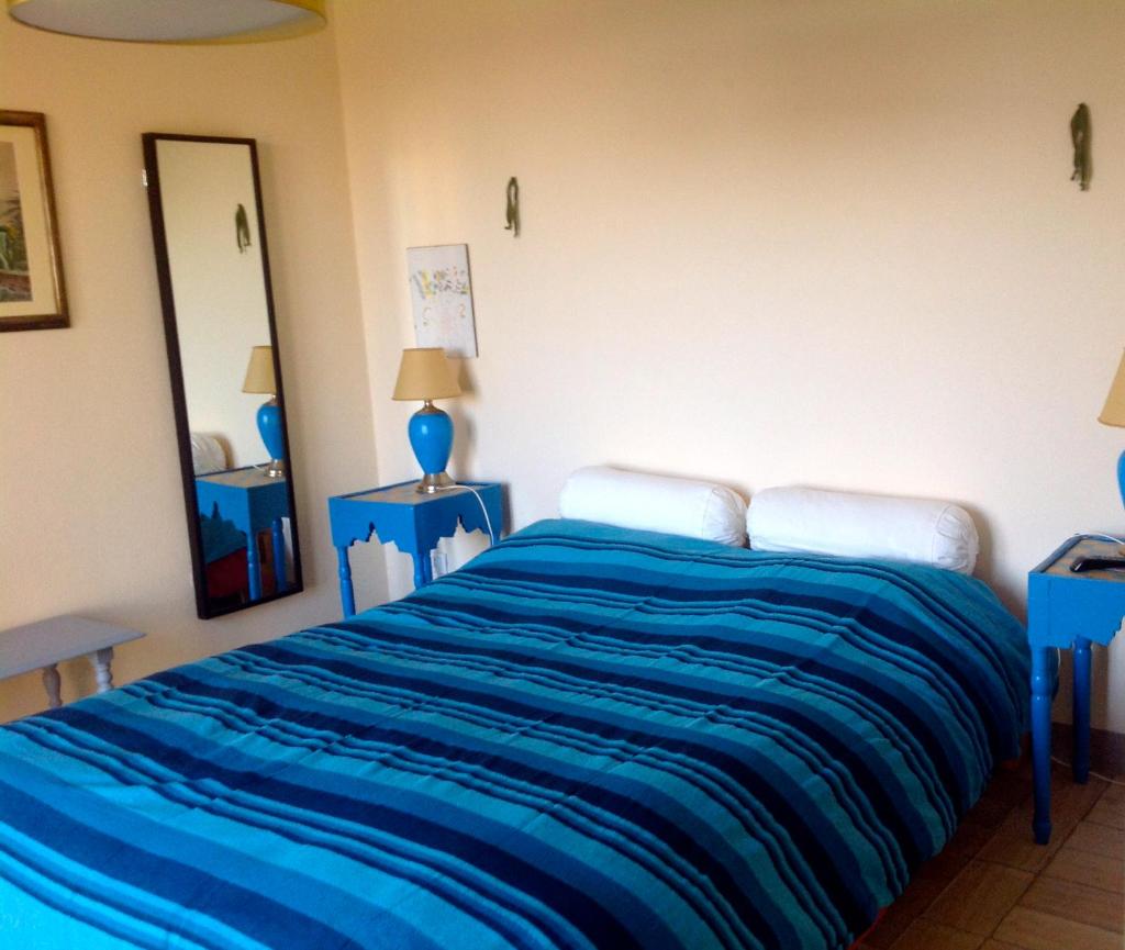 une chambre avec un grand lit avec des draps bleus dans l'établissement Villa Belvedere, à Marsiliana d'Albegna