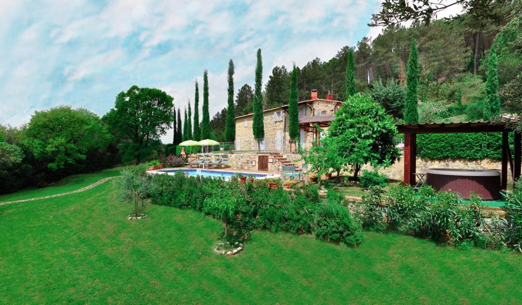 un jardin avec une maison et une piscine dans l'établissement Villa le Capanne, à Montecastelli