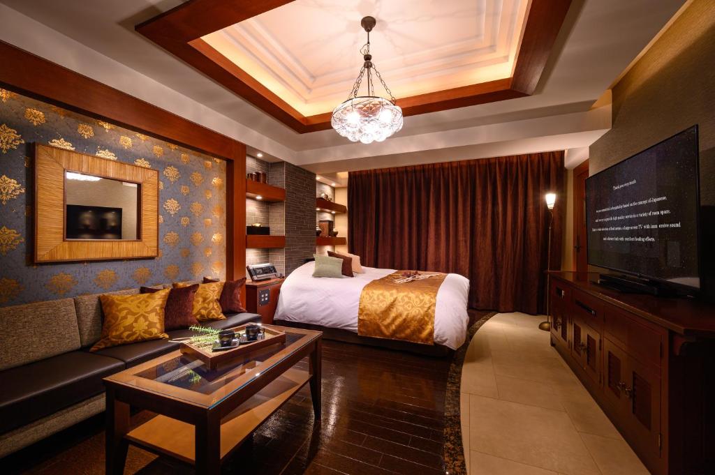 une chambre d'hôtel avec un lit et un canapé dans l'établissement HOTEL ZEN KOHOKU, à Yokohama