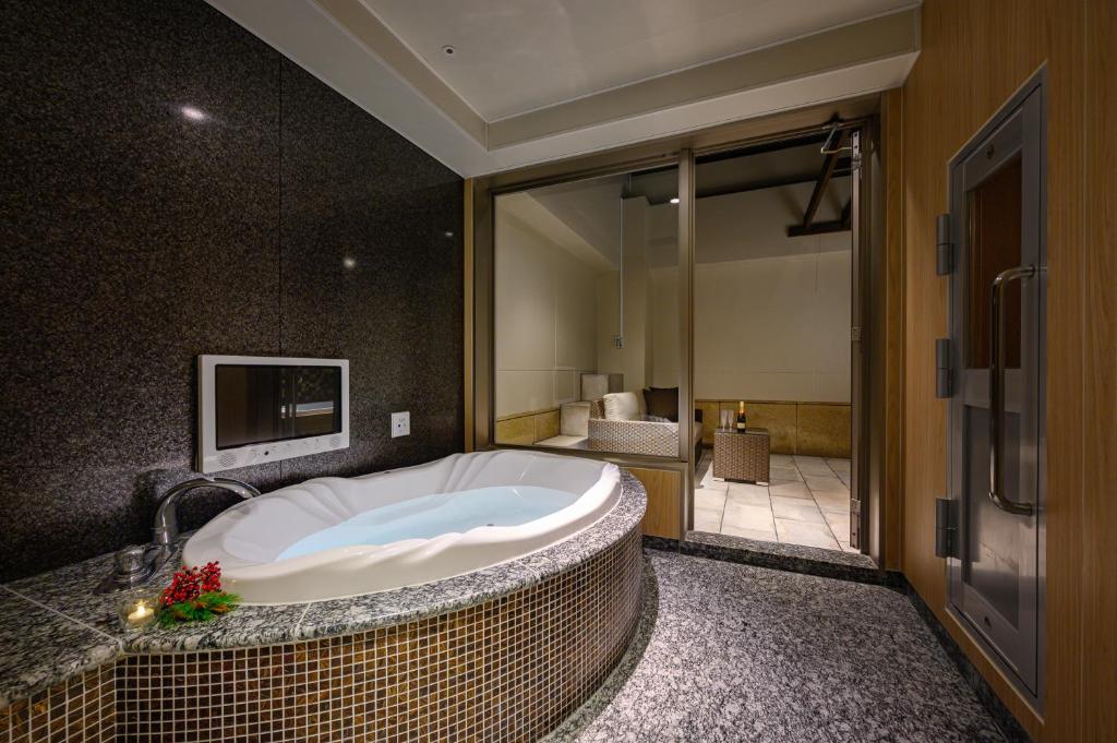 La salle de bains est pourvue d'une grande baignoire. dans l'établissement HOTEL ZEN KOHOKU, à Yokohama 24 autres photos