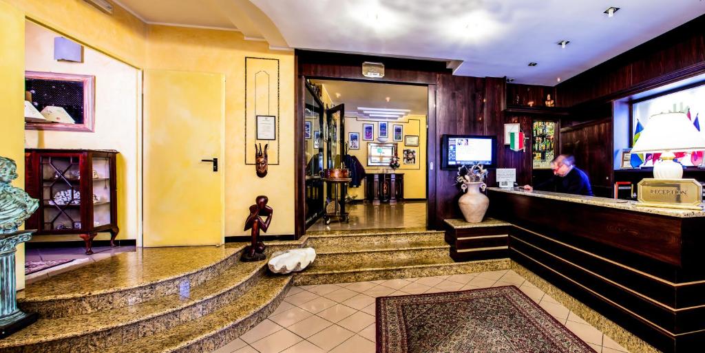 un hall d'un magasin avec des escaliers et des vases dans l'établissement Mannu Hotel, à Bosa