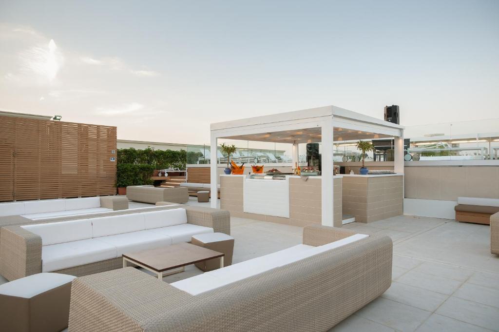 une terrasse sur le toit avec des canapés et un gazebo dans l'établissement Le Dune Suite Hotel, à Porto Cesareo