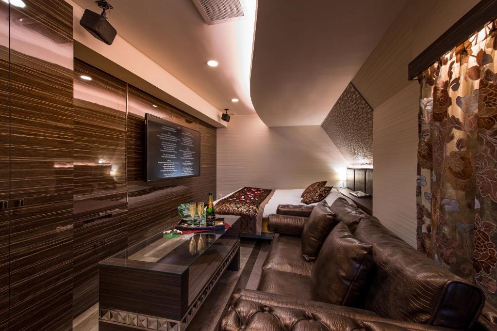 un salon avec un canapé en cuir et une table dans l'établissement Hotel Water Gate Sagamihara (Adult Only), à Sagamihara