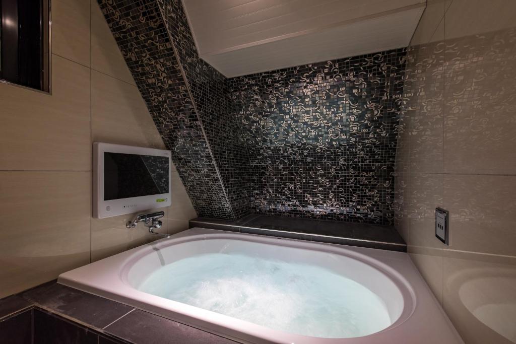 une baignoire dans une salle de bain avec une télévision dans l'établissement Hotel Water Gate Sagamihara (Adult Only), à Sagamihara