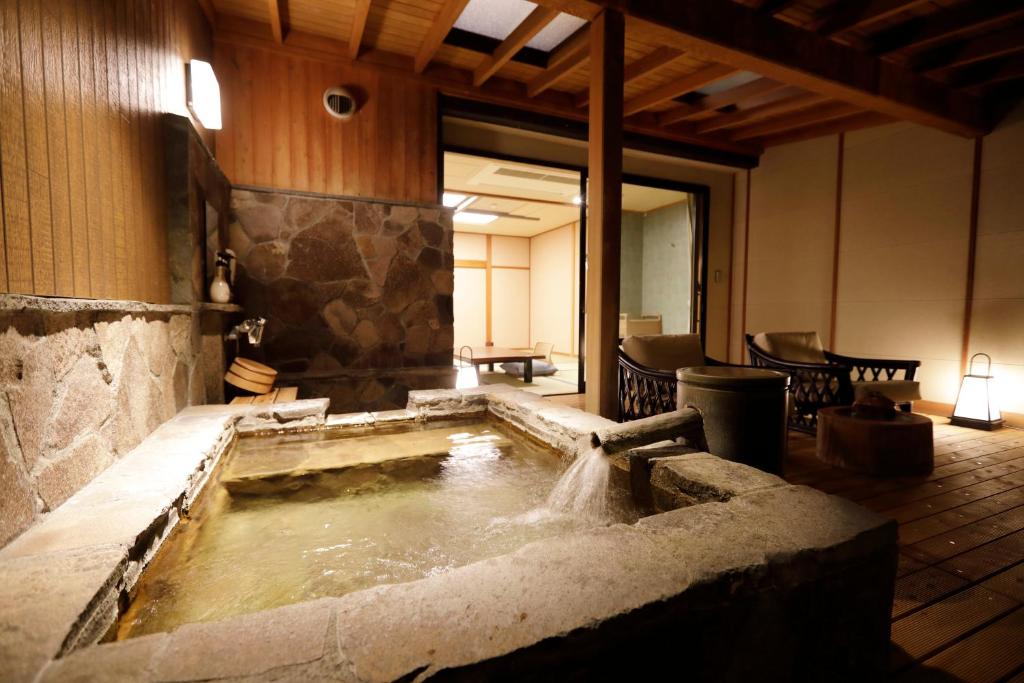 une baignoire remplie d'eau dans une pièce dans l'établissement Yumeguri no Yado Yoshiharu, à Izunokuni