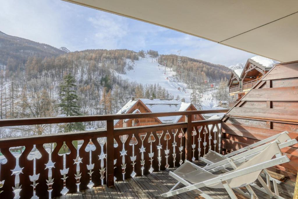 d'un balcon avec des chaises et une vue sur une piste de ski. dans l'établissement Prestigieux Appartement Pied Piste Luc Alphand 80 M2 Serre Chevalier Chantemerle, à Saint-Chaffrey