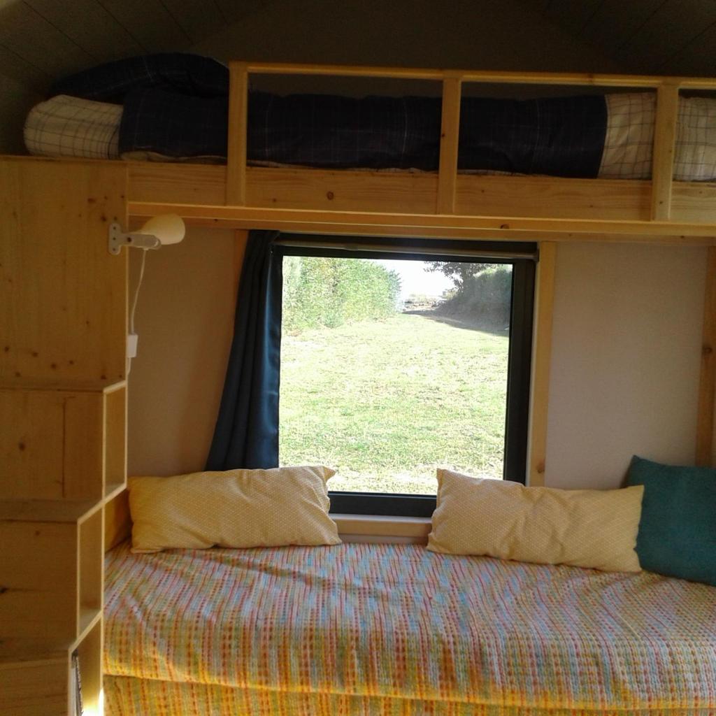 une chambre avec un lit superposé et une fenêtre dans l'établissement Tiny house sur la Presqu'île Sauvage, à Lanmodez