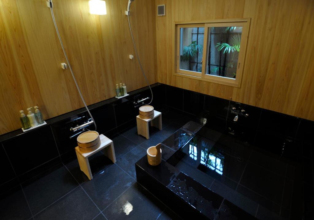 une salle de bain avec toilettes, lavabo et miroir dans l'établissement IZUYASU Traditional Kyoto Inn serving Kyoto cuisine, à Kyoto