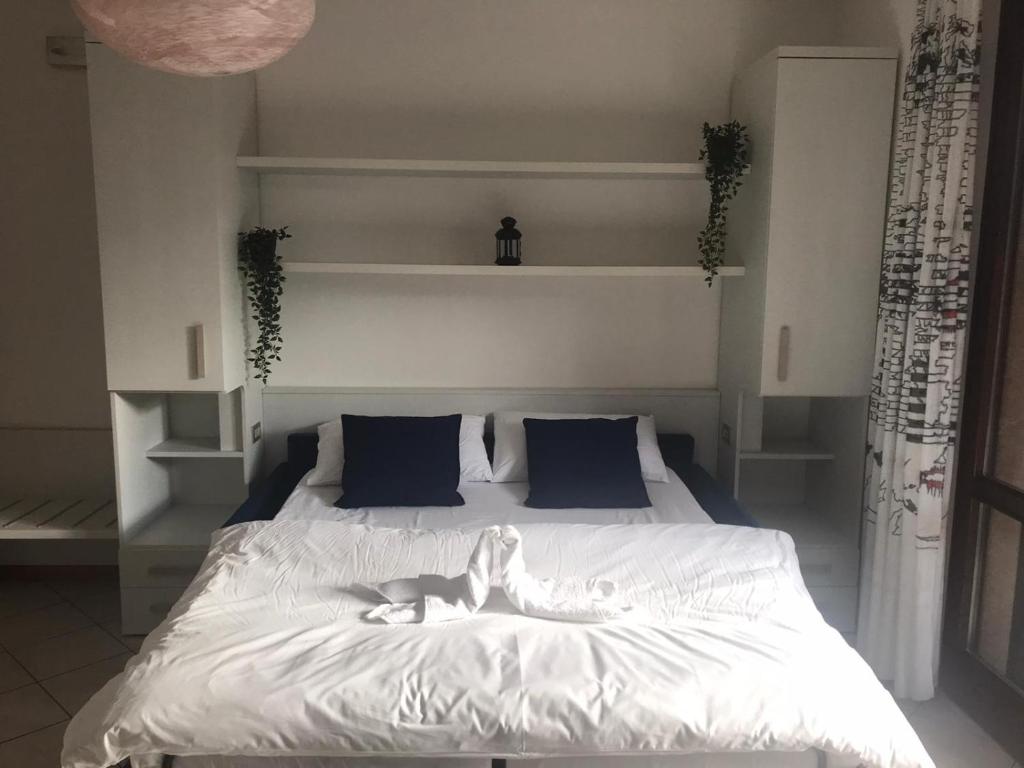 une chambre avec un lit blanc avec des oreillers bleus dans l'établissement Residence Miravalle, à Limone sul Garda 23 autres photos