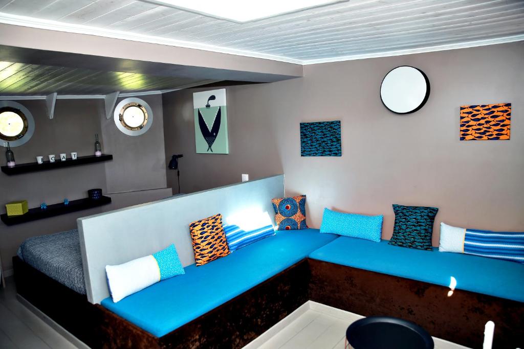 une chambre avec un canapé bleu et des réveils sur le mur dans l'établissement Le grand large, à Metz