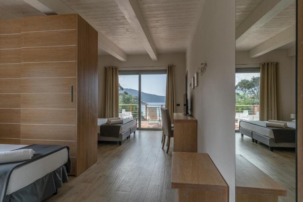 - une chambre avec un lit et un salon avec vue dans l'établissement Hotel Delfino, à Procchio