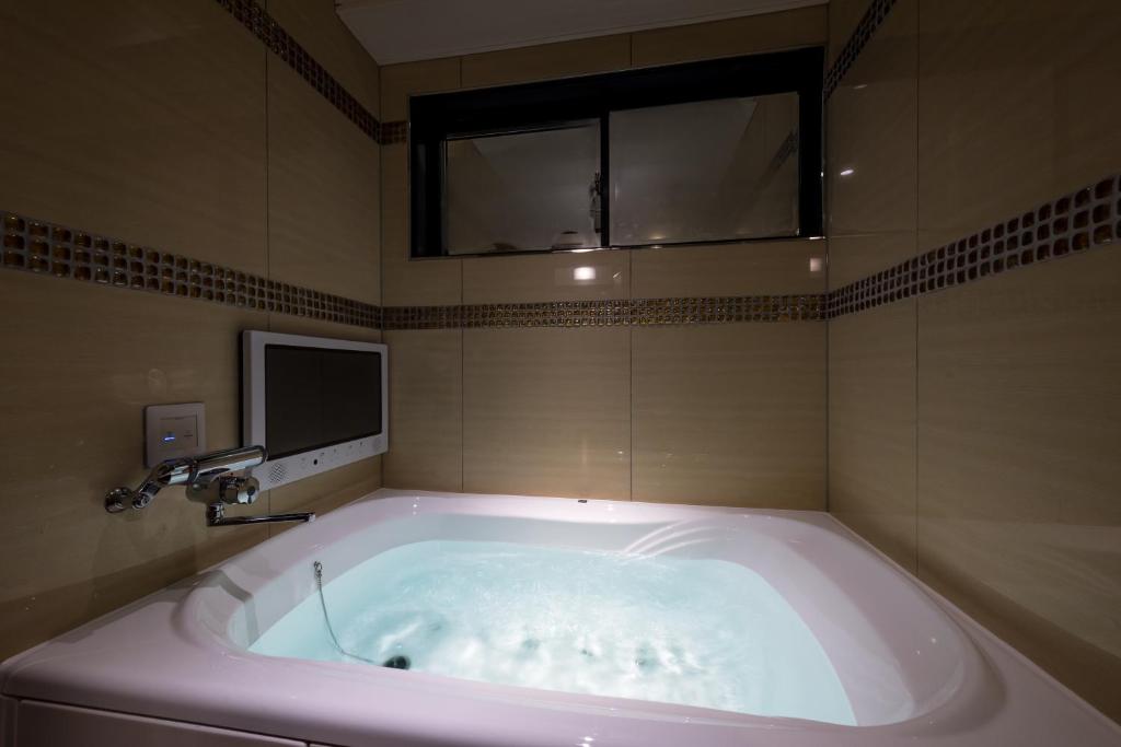 une baignoire dans une salle de bain avec une fenêtre dans l'établissement Hotel Water Gate Sagamihara (Adult Only), à Sagamihara 30 autres photos