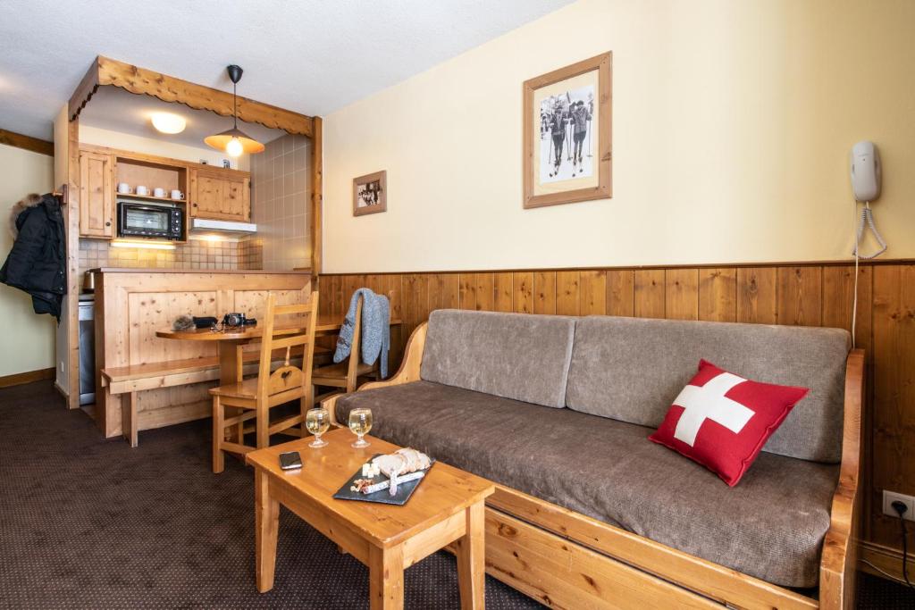 un salon avec un canapé et une table dans l'établissement Le Cheval Blanc - Village Montana, à Val Thorens