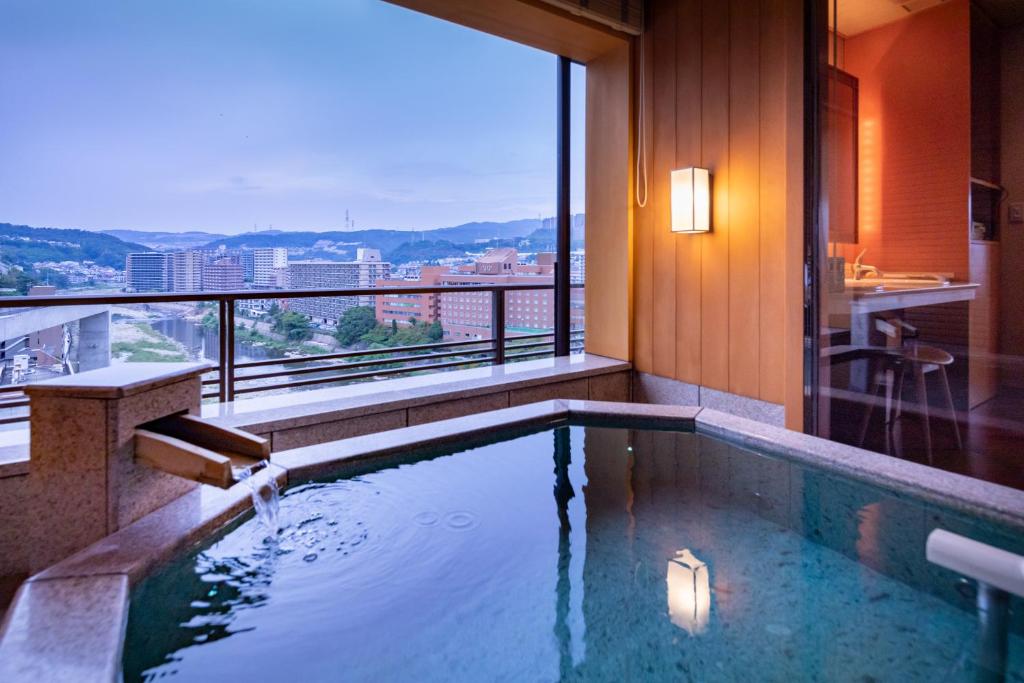 une piscine dans un hôtel avec vue sur la ville dans l'établissement Hotel Wakamizu, à Takarazuka