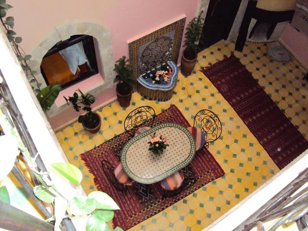 une maison en poupée avec une table, des chaises et une cheminée dans l'établissement Riad Etoile D'essaouira, à Essaouira